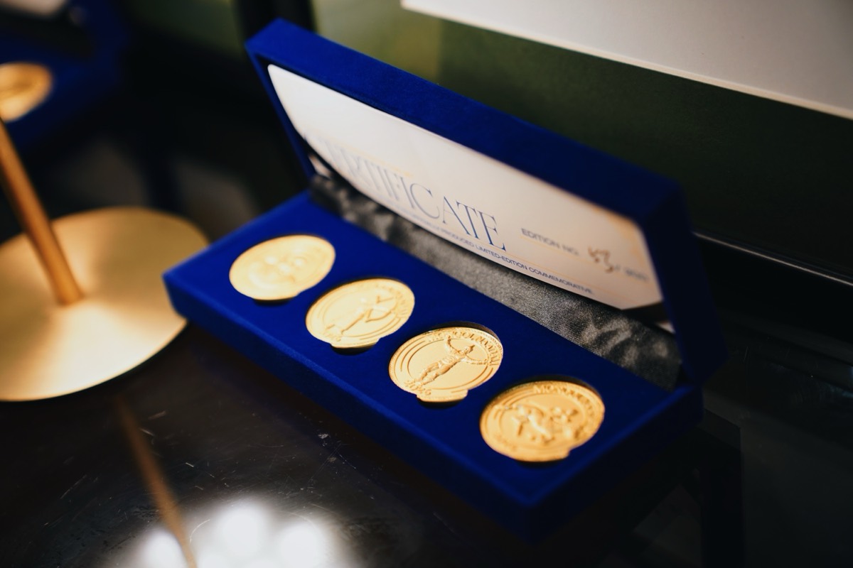 Gold commemorative coins in a navy velvet presentation box